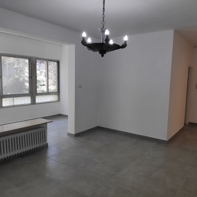 חדר עם רצפת אריחים, קירות צבועים ונברשת חדשה