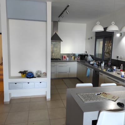 מטבח מודרני עם שולחן, כיסאות ותאורה תלויה