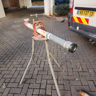 צינור מתכת על חצובה עם מלחציים