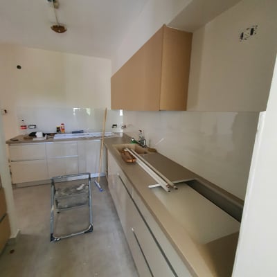 מטבח בבנייה עם ארונות וכלים על השיש