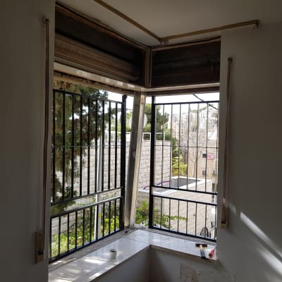 חלון עם מסגרת אלומיניום ותריסים פתוחים