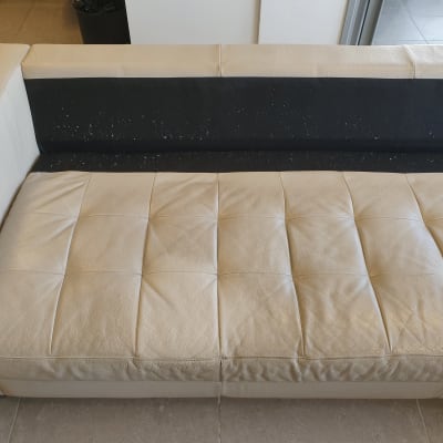 ספה בהירה עם כתמים על המושב והמשענת