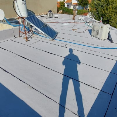 גג עם יריעות איטום, צינורות ומתקן סולארי