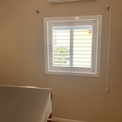 חלון עם תריסי אלומיניום לבנים