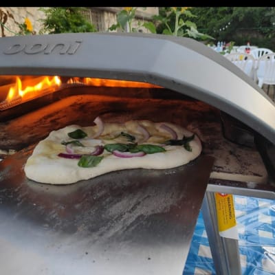 פיצה בתנור אבן עם להבות, על שולחן קייטרינג