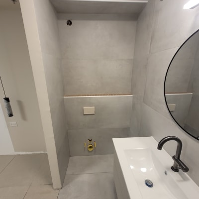 כיור לבן עם ברז בחדר אמבטיה אפור