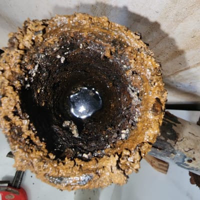 צינור חלוד עם משקעי לכלוך, מפתח צינורות אדום