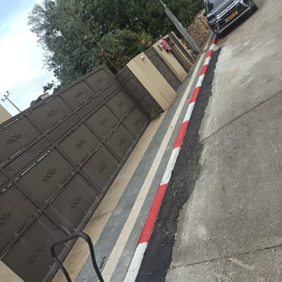 מדרכה משופצת עם צבע אדום ולבן על שפת הכביש