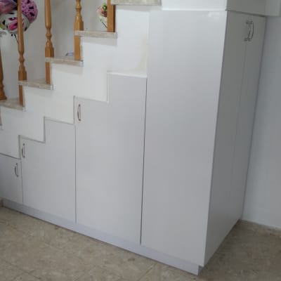 ארון לבן מתחת למדרגות עם דלתות וידיות