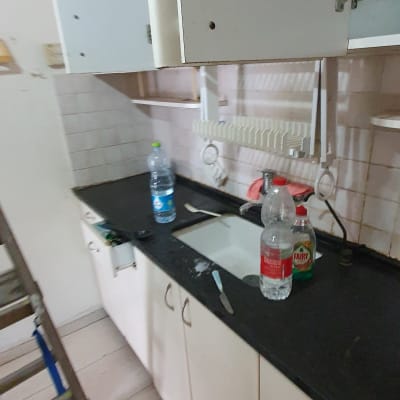 בקבוקי מים וסבון כלים על השיש במטבח