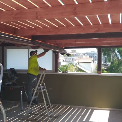 אדם על סולם מתקן פרגולה מעץ