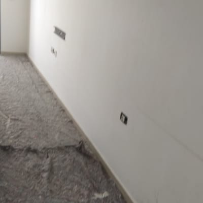 קיר צבוע לבן עם רצפה מכוסה בניילון