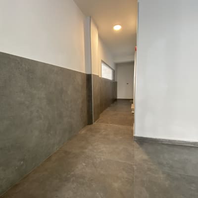 קירות ורצפה מחופים באריחים אפורים במסדרון