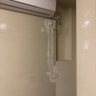 מזגן מותקן על קיר עם חוט חשמל מחובר