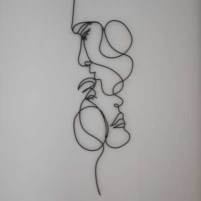 עבודת אמנות קיר מתכתית מופשטת על קיר לבן