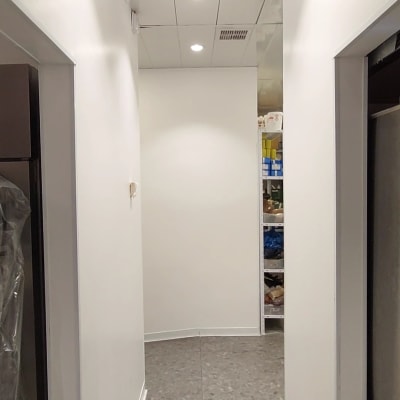 מסדרון עם קירות לבנים ותקרה עם תאורה שקועה