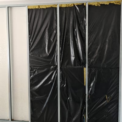 קיר גבס עם מסגרת מתכת וכיסוי פלסטיק שחור