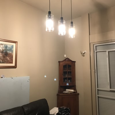 שלושה מנורות תלויות מהתקרה עם נורות דולקות