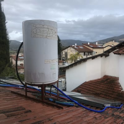 דוד שמש על גג עם צינורות כחולים ושחורים