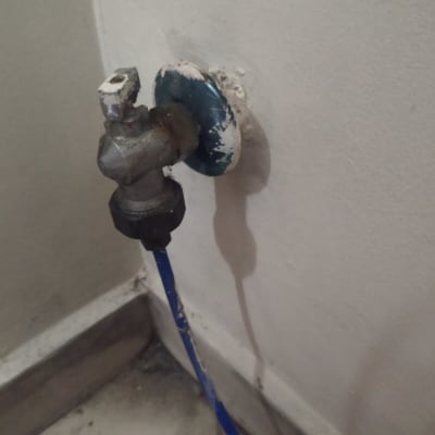 ברז מים ישן עם צינור כחול מחובר