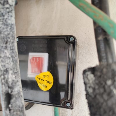 מתג חשמלי עם כיתוב אזהרה בעברית