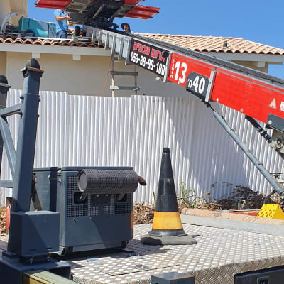 מנוף עם זרוע אדומה על גג בית