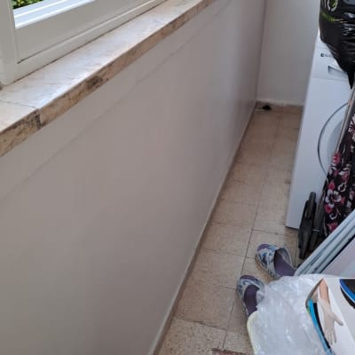 חלון זכוכית עם מסגרת לבנה על אדן אבן