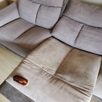 ספה עם כתמים ומברשת ניקוי על המושב