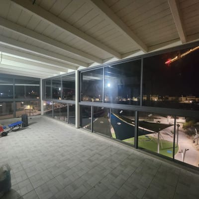 חלונות אלומיניום גדולים במרפסת מקורה בלילה