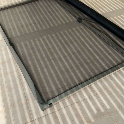 אדם מתקין מסגרת אלומיניום לרשת על הרצפה