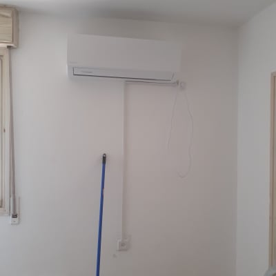 מזגן מותקן על קיר עם חוט חשמל חשוף