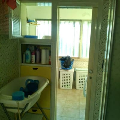 חדר אמבטיה עם כיור, ארון ומוצרי ניקוי