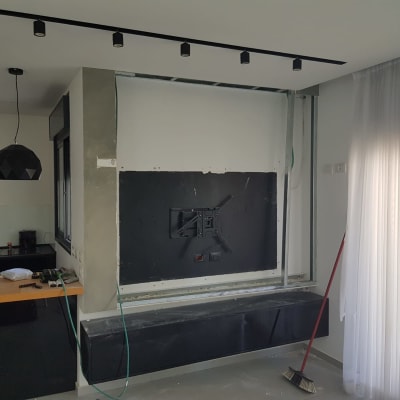 קיר עם חיפוי שחור, מטאטא בצד, הכנה לצביעה