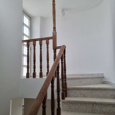 מדרגות משופצות עם מעקה עץ וחלון גדול