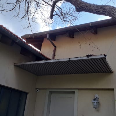 גג רעפים עם מרזב ועץ קרוב