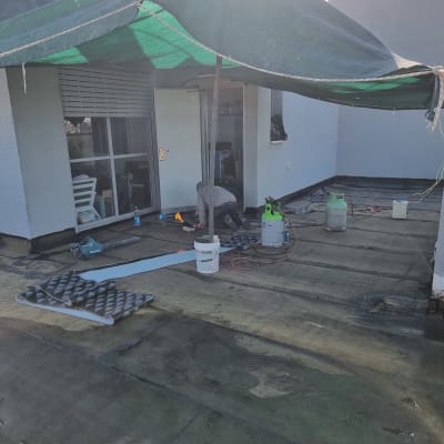 אדם עובד על איטום גג עם יריעות וחומרי איטום