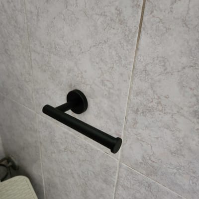 מתקן נייר טואלט שחור מותקן על קיר אריחים