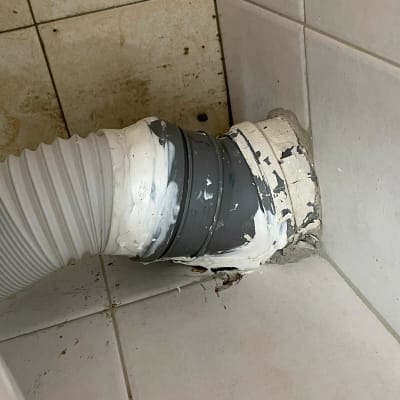 צינור גמיש מחובר לקיר עם איטום לבן