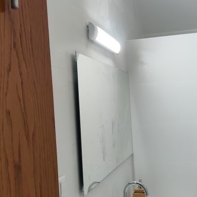 מראה עם כתמים, ברז וכיור בחדר אמבטיה