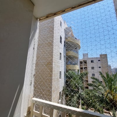 רשת הגנה מותקנת על מרפסת למניעת כניסת יונים