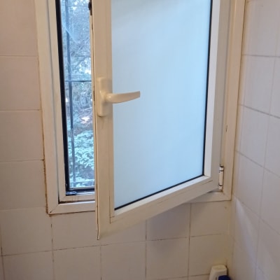 חלון אלומיניום פתוח עם ידית לבנה