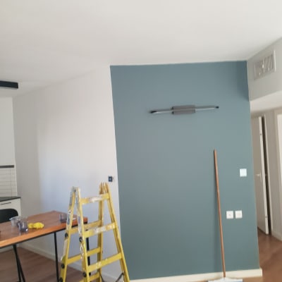 קיר צבוע בכחול עם סולם וכלי עבודה