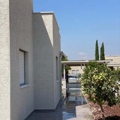 שביל מרוצף ליד קיר בניין עם צמחייה