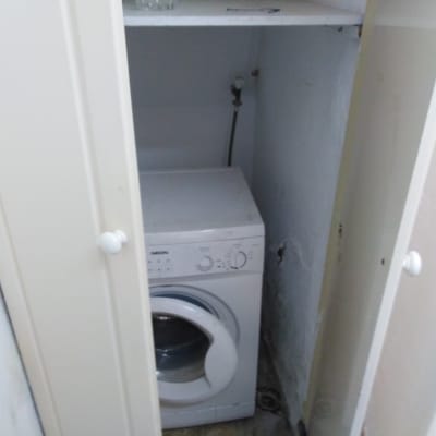 מכונת כביסה בתוך ארון פתוח