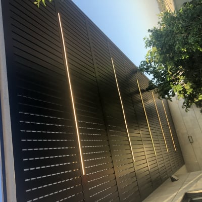 קיר עם תאורה מובנית לאורך חריצים אנכיים