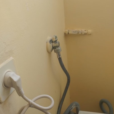 ברז מים מחובר לצינור גומי על קיר