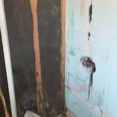 קיר מתקלף עם סימני רטיבות ושקית על הרצפה