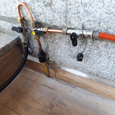 צינורות גז עם ברזים ומחברים על קיר אבן