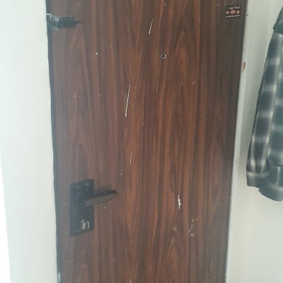 דלת עץ עם מנעול וידית שחורה