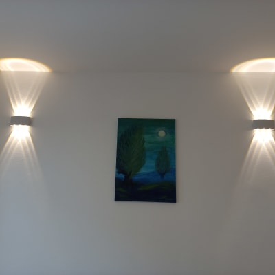 שני גופי תאורה על קיר לבן עם תמונה